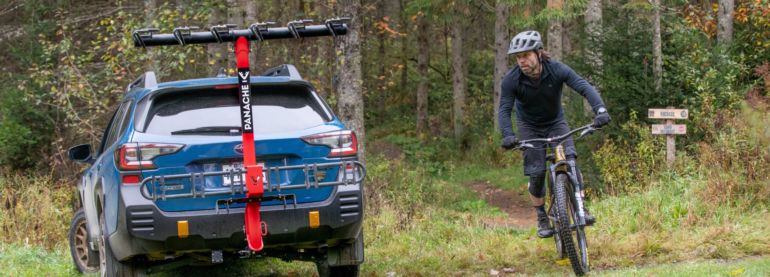 voiture Subaru équipé d'un porte-vélo Panache T6 avec un cycliste sortant d'un sentier